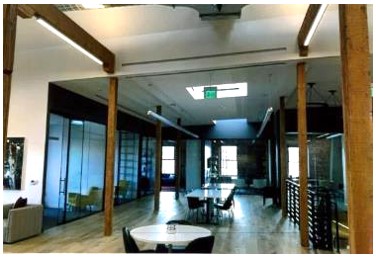 After: view of more open space from glass walls and open stairs after construction